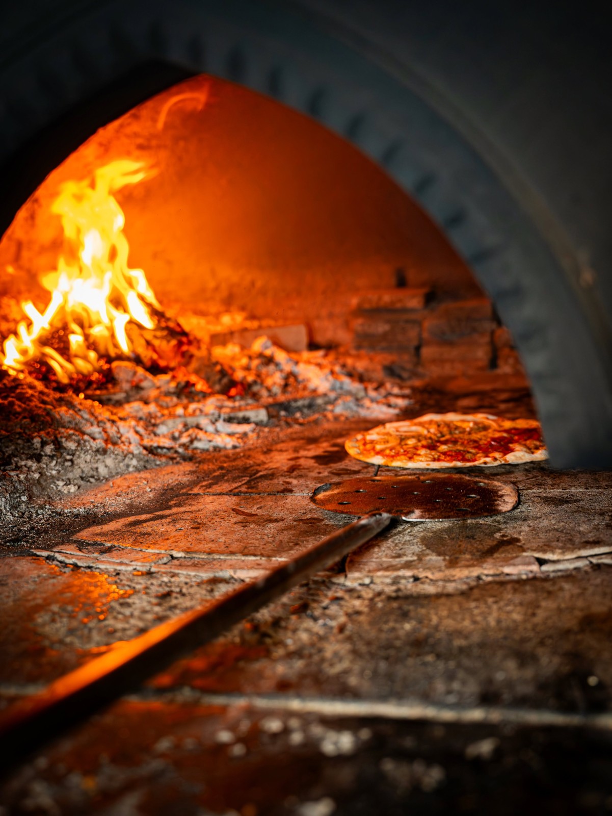 Pizza wird im brennenden Holzofen von La Tavola da Franco gebacken