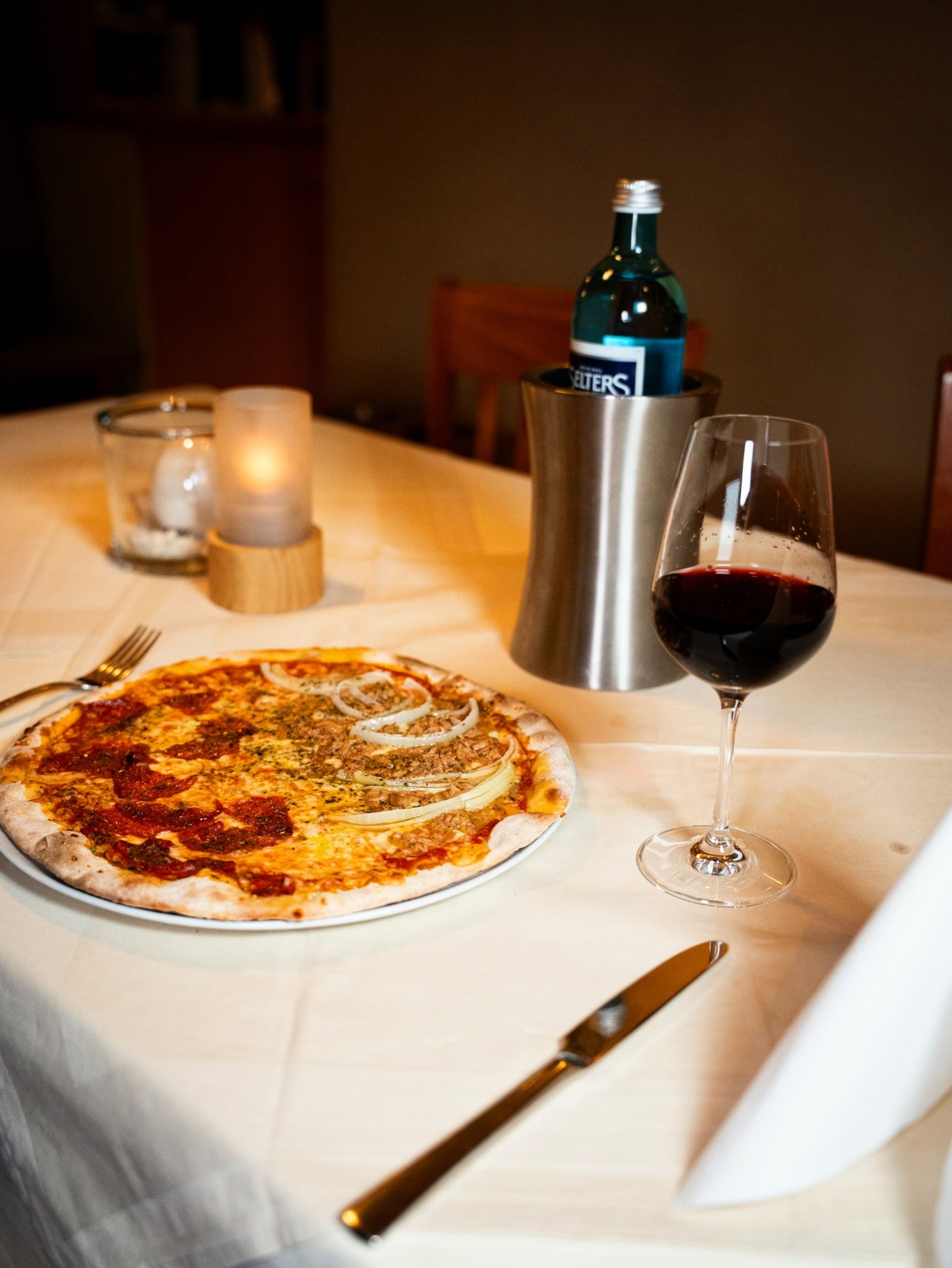 Holzofenpizza mit einem Glas Rotwein im Restaurant